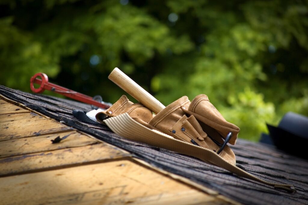 Ideal Roofing and Construction, toolbelt laying on a roof in repair