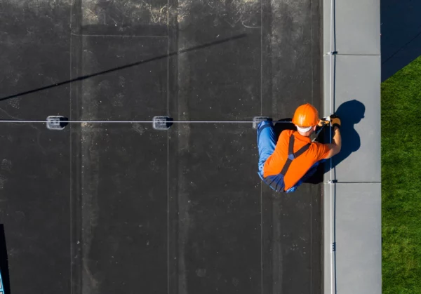 Ideal Roofing and Construction flat roofing, worker in high-vis marking seams